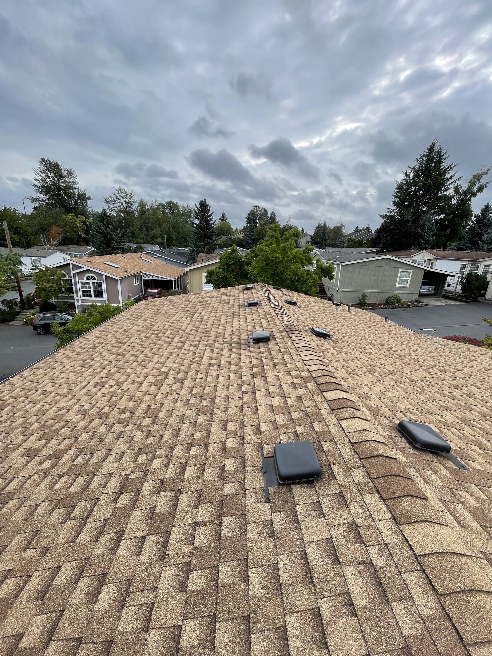 Older brown shingle roof before repair, wide rooftop view