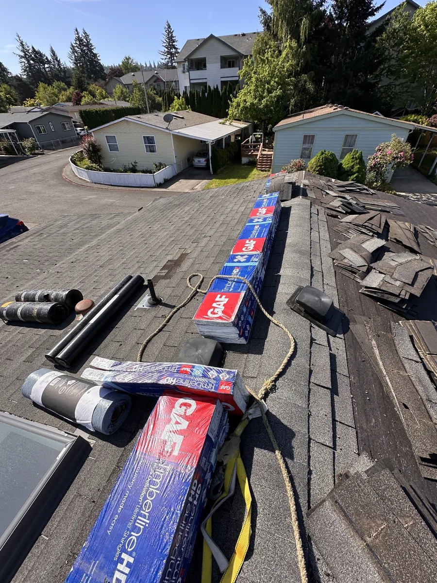 Removed shingles piled on ridge during tear-off, roof replacement in Portland OR